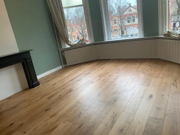 Houten plankenvloer in een woonkamer met erker